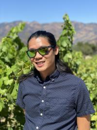 A portrait of Garfield Kwan, wearing sunglasses and a dark colored shirt, standing in front of a background of greenery outdoors.A portrait of Garfield Kwan, wearing sunglasses and a dark colored shirt, standing in front of a background of greenery outdoors.