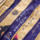 UC Davis graduate stoles showing the words "UC Davis", "First Generation" "Global Aggies" and "Legacy"